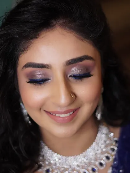 A close-up of Aditi's reception look, showing the smile behind the sparkle. The pop of blue eyeliner adds a fun, modern twist to the glamorous glittery eye.