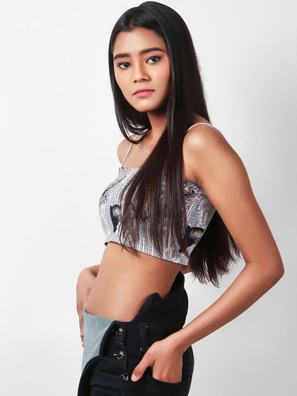 A model wearing a printed crop top and overalls, captured in a confident pose for a fashion-forward brand.