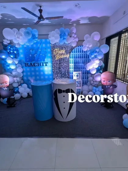 I bring popular movie themes to life, like this complete Boss Baby decoration for a first birthday. The setup includes a custom printed backdrop, themed pedestals for the cake, character cutouts, and a blue and white balloon arch to create an immersive experience.