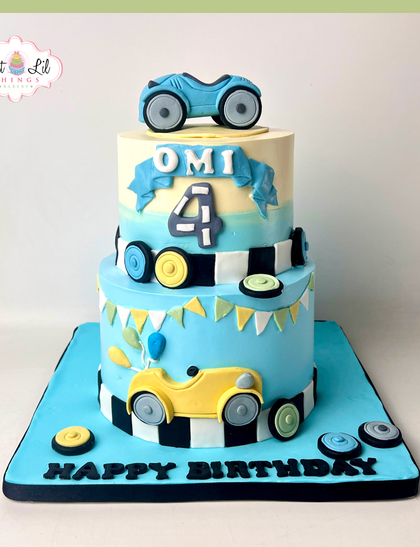 Ready, set, go! A two-tiered race car cake for a 4th birthday. The design features checkered flags, fondant cars, and a fun, playful vibe for a little speedster.