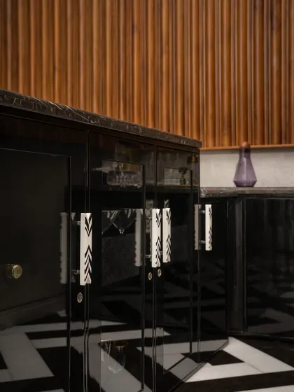 A close-up of the bar's cabinet handles and the black-and-white marble floor. Every detail, from the material choice to the custom craftsmanship, contributes to the space's unique and luxurious character.