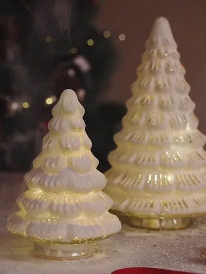 Create a snowy wonderland for your holidays. These white glass LED Christmas trees look like they are dusted with fresh snow, bringing a magical and serene winter vibe into your home.