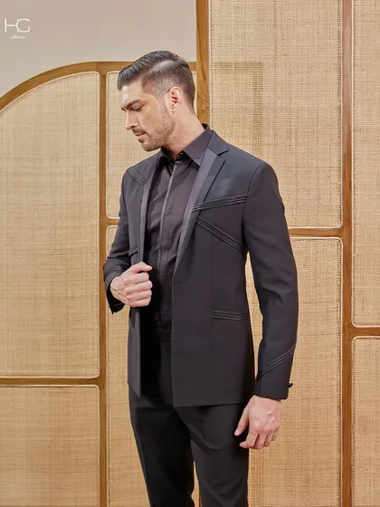 This suit is a statement in precision, power, and presence. The geometric stitched lines on the jacket create a unique visual interest, elevating it beyond a simple black suit.