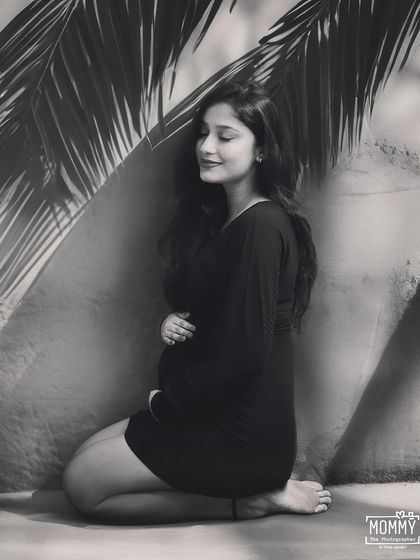 A moment of pure calm and connection with her baby. This serene, kneeling pose in black and white creates a peaceful and introspective maternity portrait.