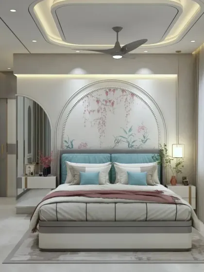 A beautiful bedroom design featuring a custom arched headboard with a delicate floral mural. The false ceiling with cove lighting and the integrated vanity area complete this dreamy and feminine space.