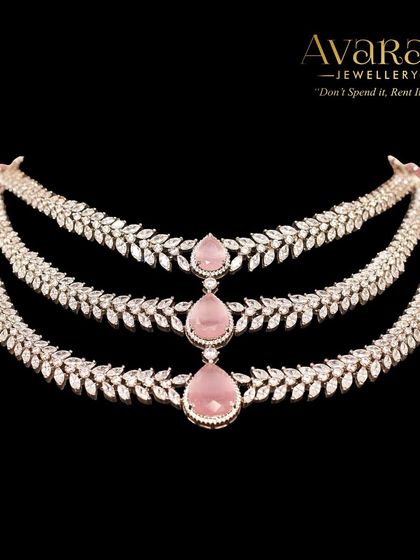 A delicate and feminine three-layered necklace with pink stones and leaf-patterned zircon chains. Perfect for a soft, romantic look.