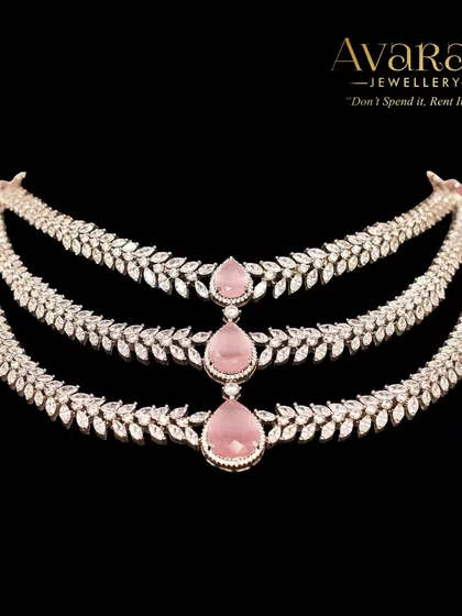 A product shot of the three-layered zircon necklace with pink stones. The delicate design and soft color make it a romantic and elegant choice for any special occasion.