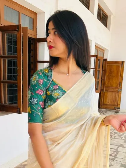 Another angle of the client in her off-white saree, showing the V-neck and detailed embroidery of the green blouse.
