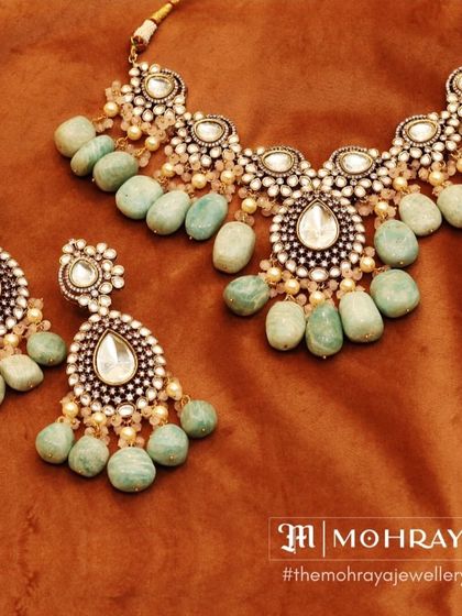A stunning polki and kundan necklace set with light green tumbled beads. This unique design is perfect for a bride who wants something different.