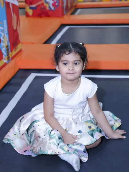 A little girl takes a quiet moment on the trampoline. Our play zone has areas for both high-energy action and moments of calm.