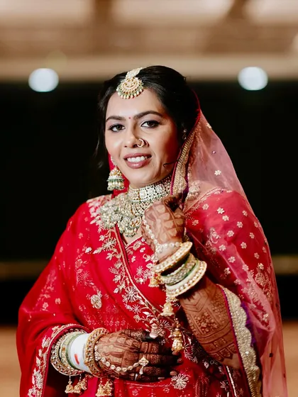 A classic portrait of a bride in red. Her makeup is kept soft and radiant to let her natural beauty and stunning jewelry take center stage.