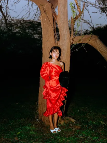 A vibrant shot from a spring fashion shoot. I styled this bold, red one-shoulder dress with ruffles against a dark, natural backdrop, using a flash to make the color pop and create a dramatic, high-contrast image.