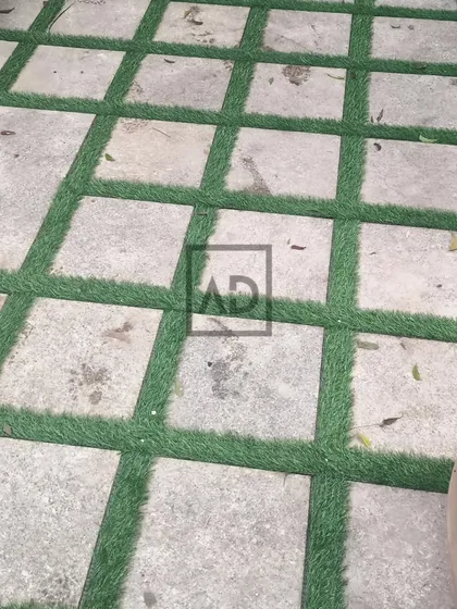 A creative flooring solution where I've laid artificial grass in the gaps between large stone pavers. This creates a unique, geometric look for a patio or walkway.
