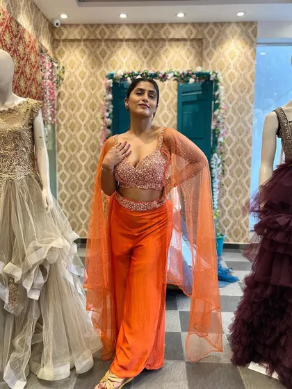 A full-length view of Chandna Gowda in our orange Indo-Western outfit, perfect for a festive occasion.