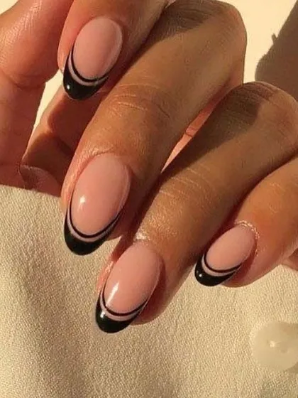 A chic and modern take on a classic, this design features a clean, double-lined black French tip on a perfectly shaped oval nail. It's an elegant and minimalist style that elevates any look with its sophisticated graphic detail.