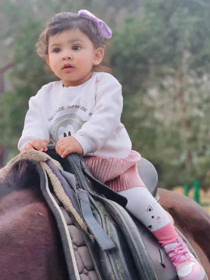 A close-up of a young child securely seated on the saddle. Our team is always on hand to assist during photoshoots with children to ensure their comfort and safety.