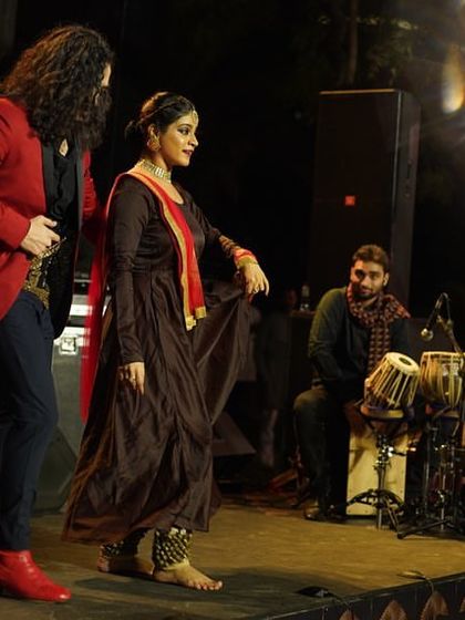 A wide shot of a performance, showing the beautiful stage design and the interaction between dancers and musicians.