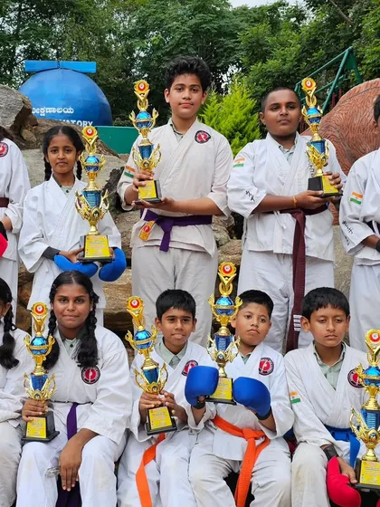 Our team of young karateka posing with their trophies. Each student, from white belt to black belt, is a valued member of our competitive team.