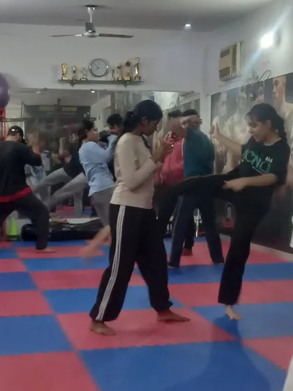 Two beginners practice their fighting stance and kicks. I ensure everyone starts with a strong foundation in martial arts basics.