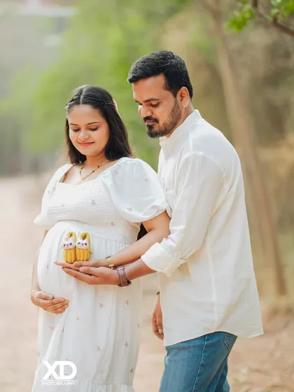 A tender moment as the couple looks down at the tiny baby shoes they are holding.