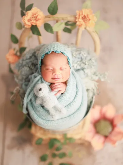 Cradled in hues of sea blue and peach petals. This combination of colors and props creates a delicate and artistic masterpiece.