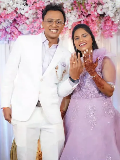 The couple proudly showing off their engagement rings. The bride is wearing a modern lavender gown with soft, romantic makeup.