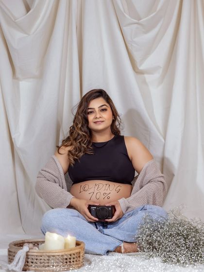 A fun and modern pregnancy announcement idea. The "Loading 70%" written on her belly is a playful nod to the digital age.