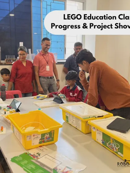 Parents and instructors gather around a student's project at Vidyashilp Academy. Our showcase events create a community of learners and celebrate the hard work of our students.