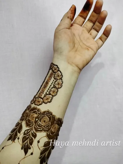 A finished henna arm band design after the paste has been applied. This style is perfect for bridesmaids or party guests who want something elegant but not as extensive as a full bridal design.