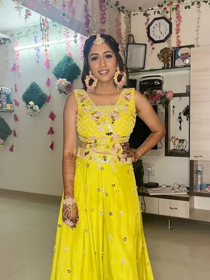 A full-length view of this stunning Haldi bride. The bright yellow lehenga and fresh, dewy makeup create a look that is full of joy.
