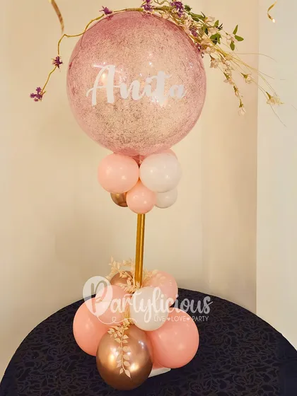 A personalized bubble balloon in soft pink and rose gold, adding a touch of simple elegance to a birthday celebration.