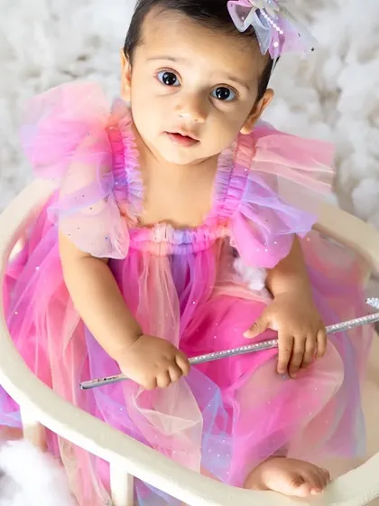 A close-up of our little fairy, holding her magic wand. Her curious expression and beautiful dress make this a truly special portrait.