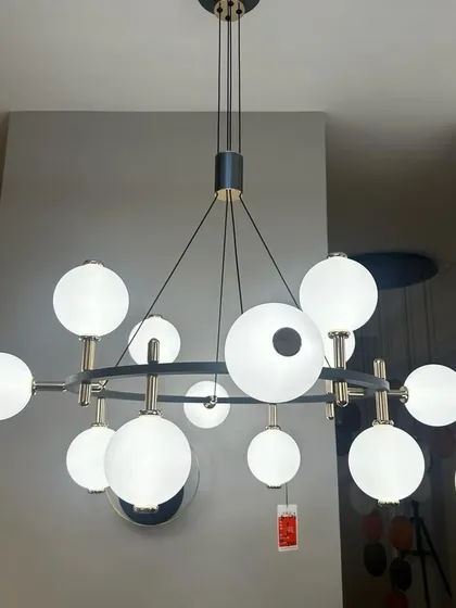 A modern ring chandelier with multiple frosted globe lights. This stylish hanging fixture is perfect for illuminating a dining area or living room with a clean, contemporary aesthetic.
