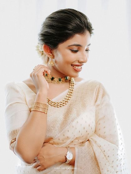 A radiant portrait of a bride in a beautiful white and gold saree, a lovely fusion of Christian and Indian wedding styles.