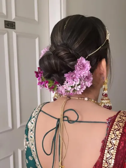 A lovely bridal bun decorated with fresh purple flowers. We love customizing the floral arrangements to match the bride's outfit and theme.