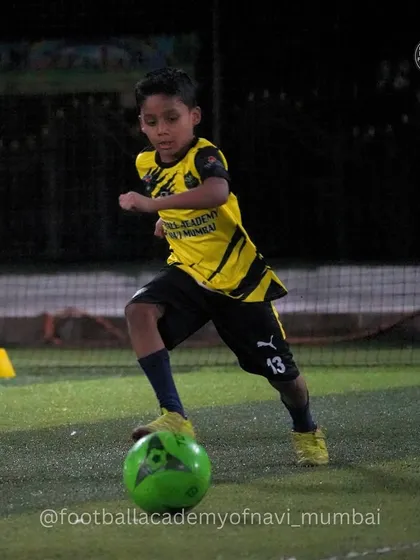 A young player dribbles with focus, developing the fundamental skills for future success.