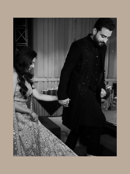 A black and white shot of the couple holding hands as they walk. This image focuses on their connection, creating a timeless and elegant pre-wedding portrait.