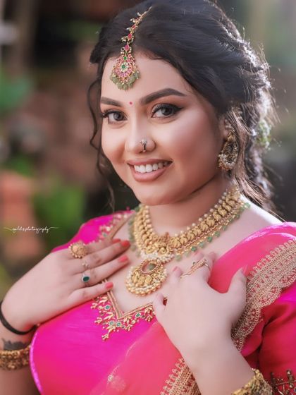 A close-up portrait focusing on the bride's happy and content expression. The soft lighting enhances her features and the intricate details of her jewelry.