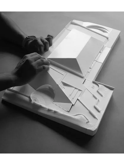 Assembling the 3D-printed model for the "Figured Ground" sports arena. This image captures the hands-on nature of our design process, where physical models are essential tools for understanding form and space.
