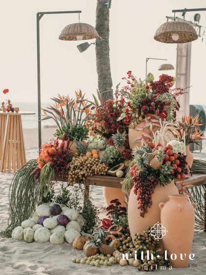A stunning installation of tropical fruits and flowers on the beach, a true feast for the senses.