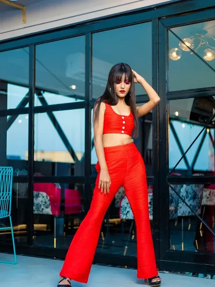 This image captures the attitude of the modern fashion shoot, with the sleek hair and dramatic red makeup creating a powerful look.