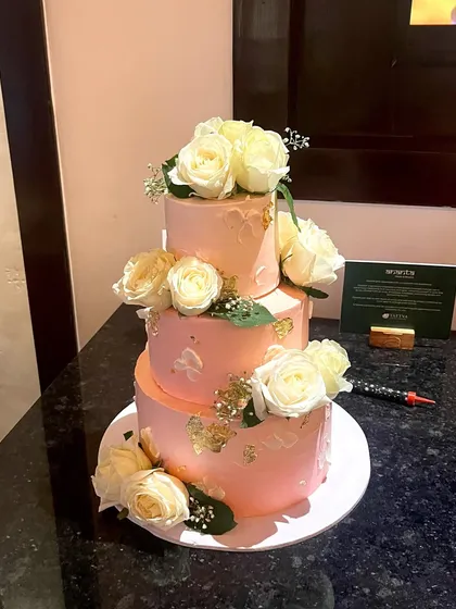 For grand celebrations, I love creating tiered cakes like this one. This three-tiered beauty features a vanilla sponge, is filled with fresh strawberry and blueberry filling, and is decorated with fresh white roses and delicate gold leaf accents.