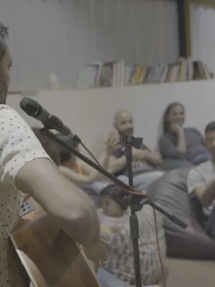 A shot of me performing music for an engaged audience. The intimate setting makes for a powerful experience.