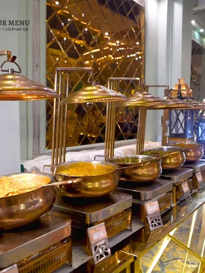 An elegant main course buffet line with golden chafing dishes, showcasing a luxurious and well-organized food display.