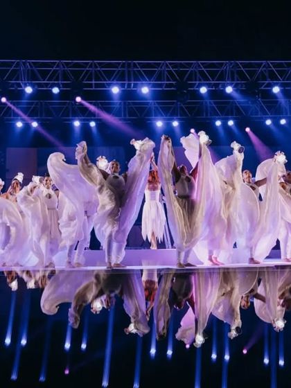 The reflection of the dancers on the mirrored stage, adding another layer of visual beauty to the performance.