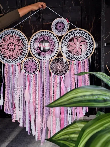 A close-up shot of the large pink personalized dreamcatcher, held up to show its scale and intricate details.