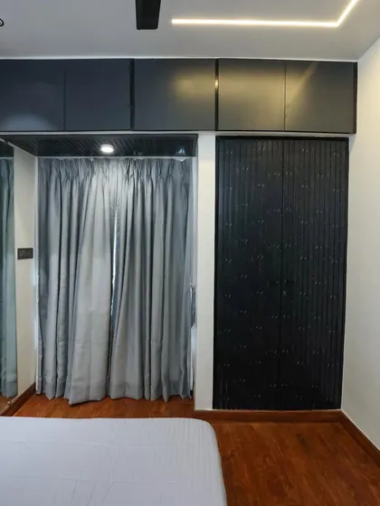 To achieve a rustic and industrial feel, we used charcoal louvered planks for the wardrobe and dark grey curtains, contrasting with the light walls.