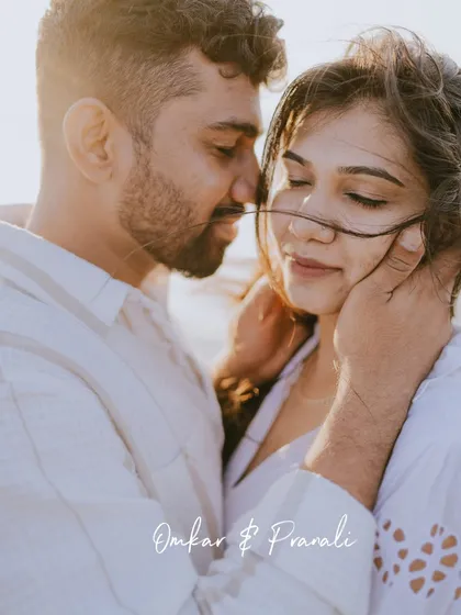 A close-up portrait with beautiful backlighting from the setting sun. The wind gently blowing the bride's hair across their faces adds a soft, romantic touch.