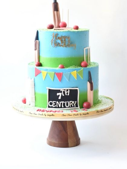 A two-tier cricket theme cake for a 7th birthday, or "7th Century." This Chocolate Truffle cake is decorated with bats, wickets, and balls, perfect for a cricket fan.