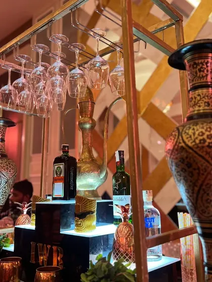 This angle highlights the ornate, hand-painted traditional vases and the integrated glass rack, blending functional bar design with authentic, artistic decor elements.